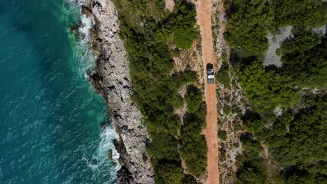 Car-driving-along-coastal-Gjipe-Beach,-Ionian-Sea,-VlorÃ«-County,-Albania