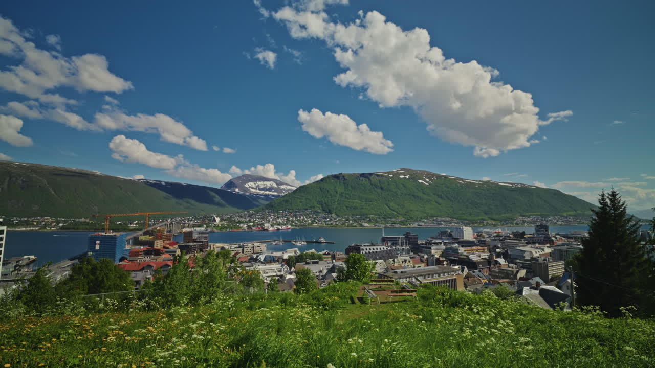 Panoramic view of the Norwegian Fjords in Tromso, Norway. View of the city, landscape sea and mountains. Bright blue sky with fluffy clouds.