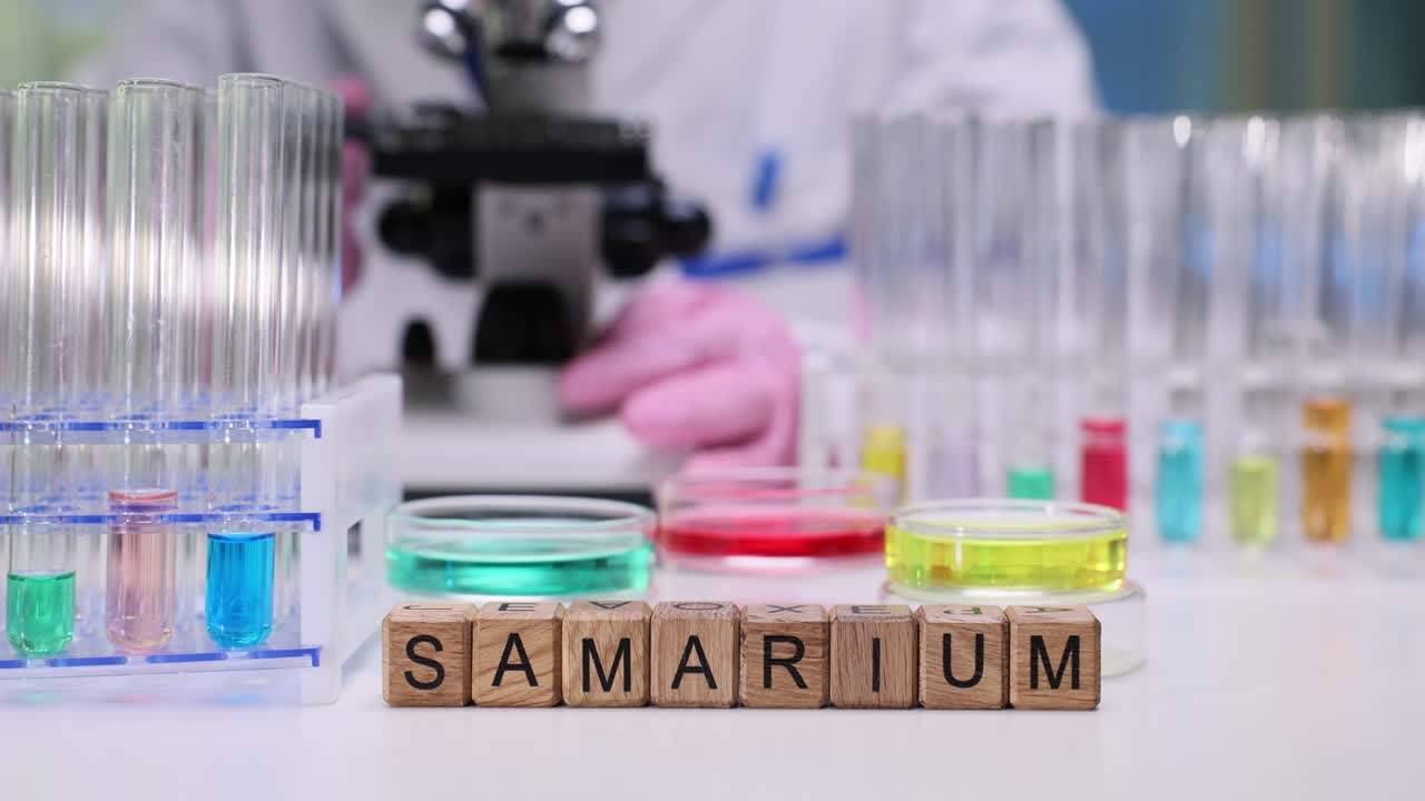 Chemist adjusts microscope controls to improve clarity by tubes