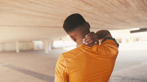 a sporty young man rubbing his neck