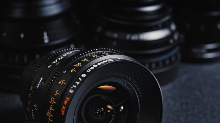 A Packshot of an expensive cinema lens in front of other cinema lenses.