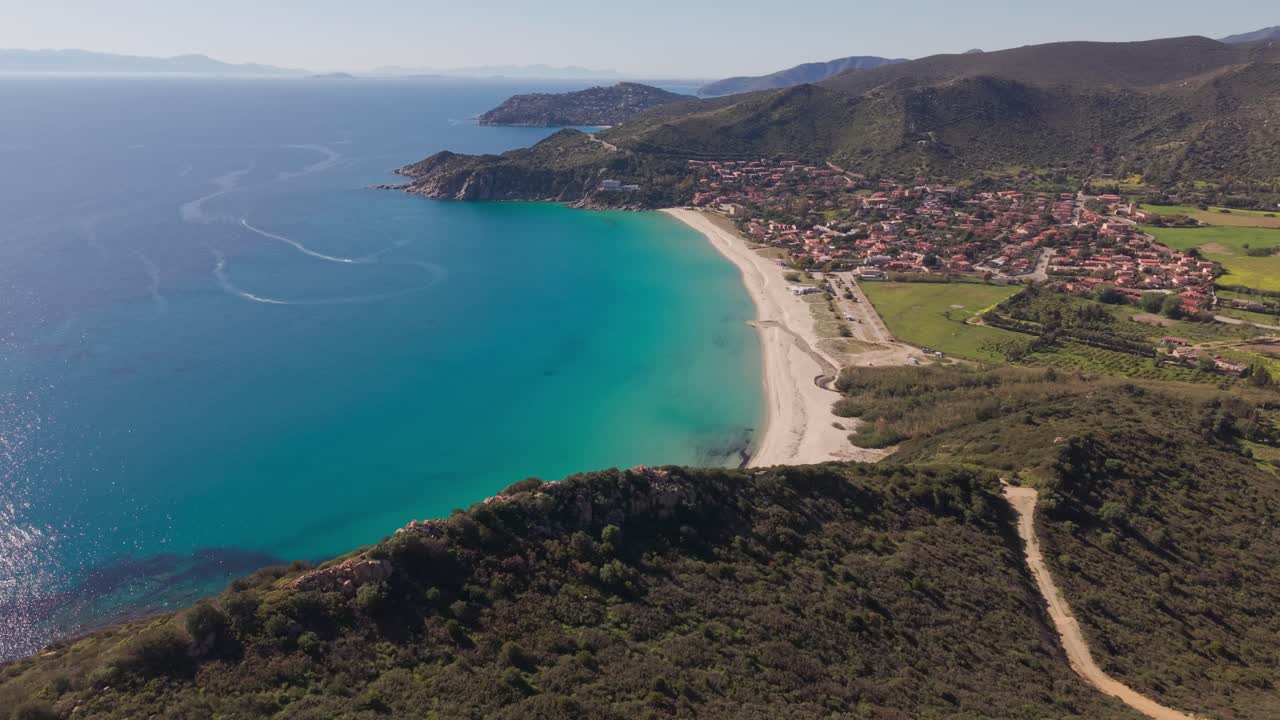Solanas sahil kasabası, Akdeniz kıyısı, Sardinya dağ doğası ve yaz tatilini keşfeden havadan drone uçuşu.