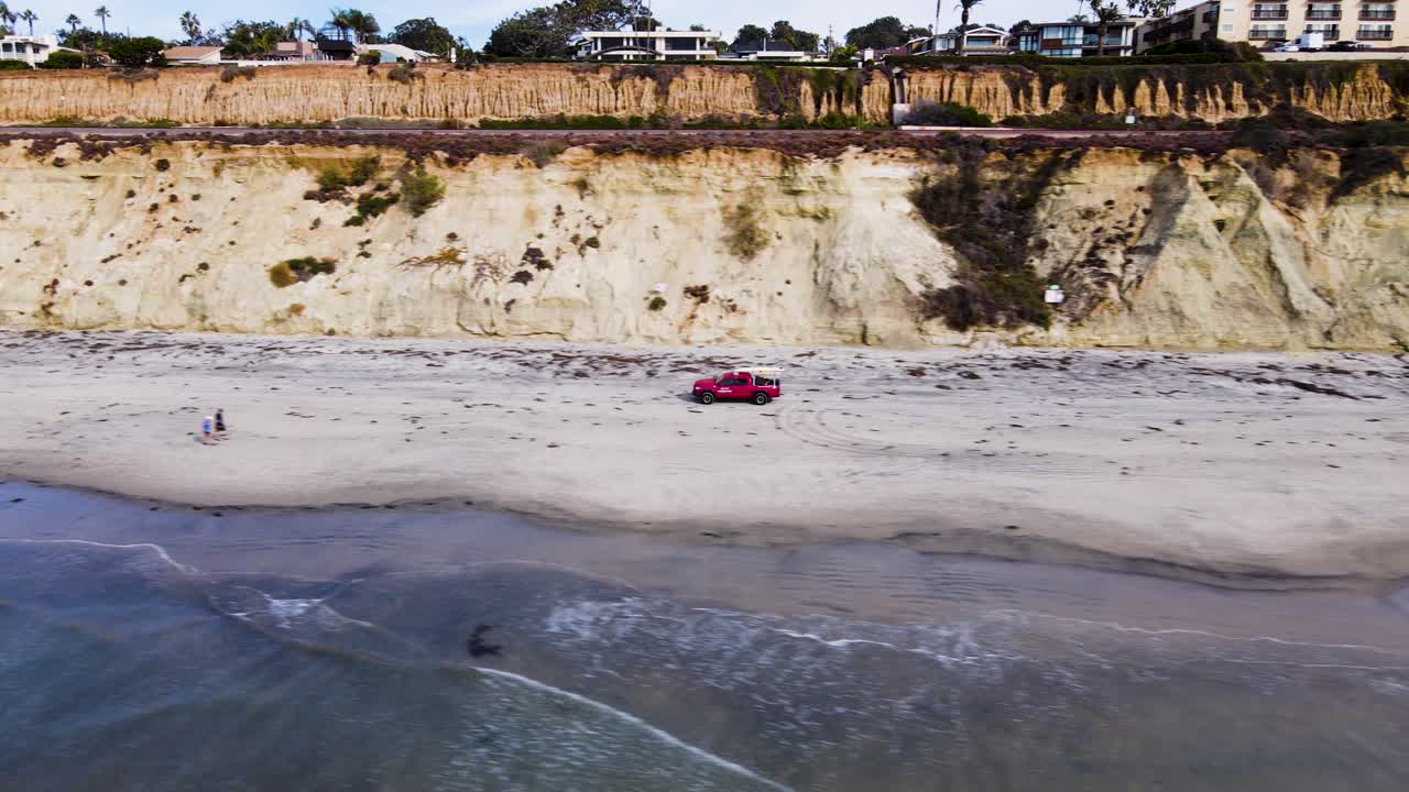 델마 해변을 주행하는 인명 구조원 트럭의 무인 항공기 보기