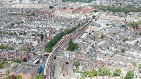 follow drone shot of london underground train arriving at parsons green station