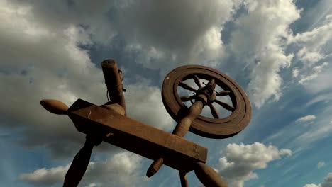 historical old wooden spinning wheel and clouds, time lapse