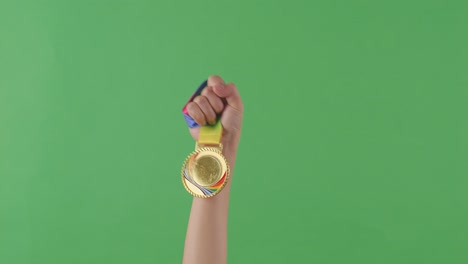 medalla de oro en la mano. fondo de pantalla verde
