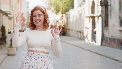 happy cheerful redhead woman showing ok gesture positive like sign approve something good celebrate