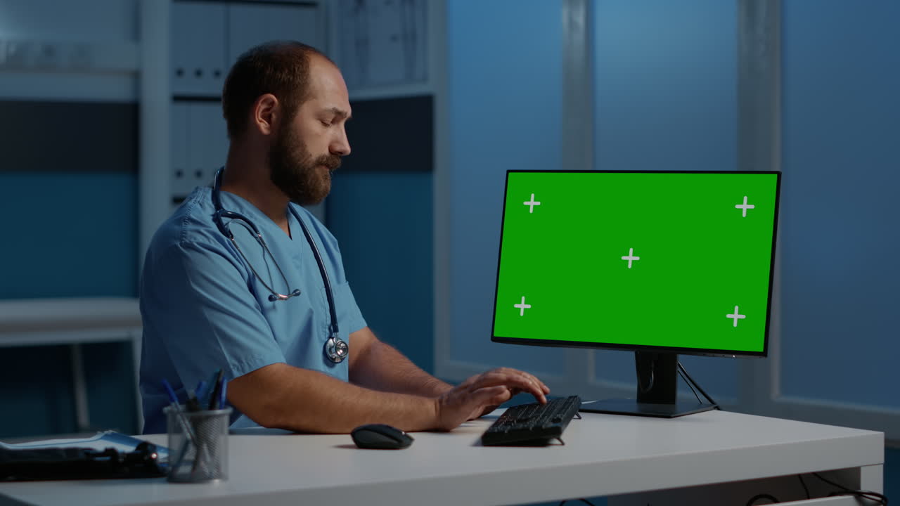 Doctor working on computer with green screen
