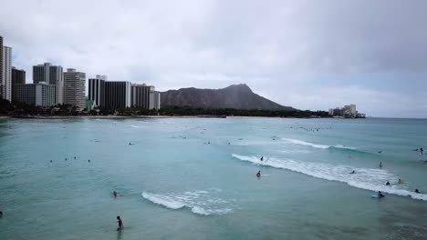 crowded surf lineup at waikiki beach, honolulu, hawaii, aerial drone view