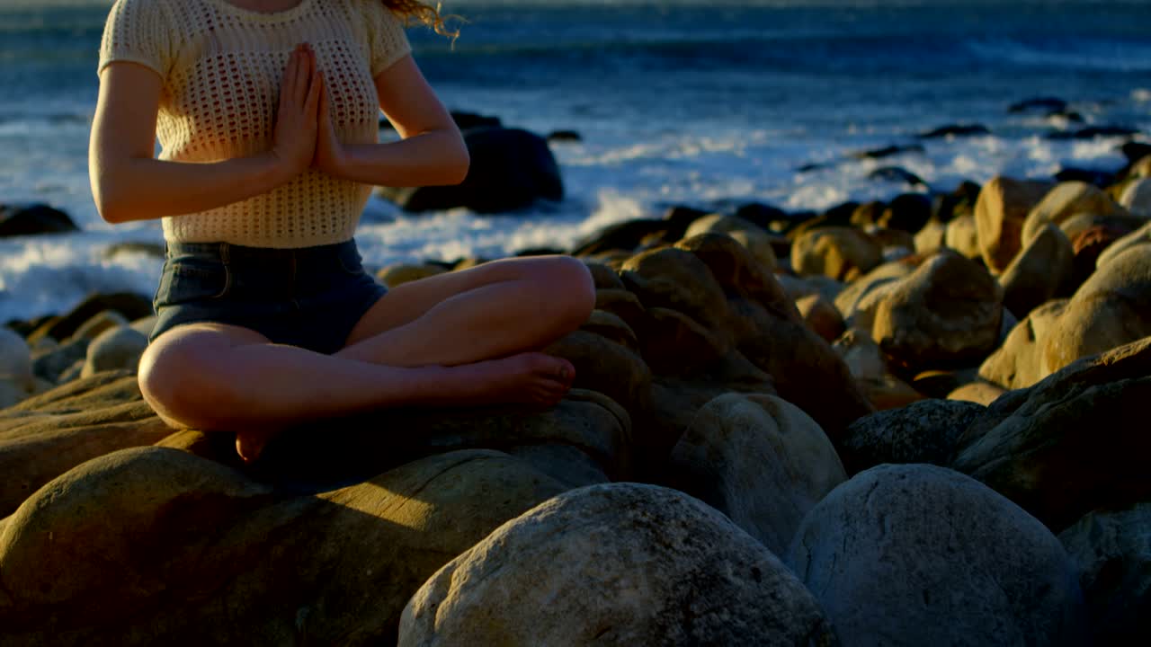 mujer realizando yoga en la playa 4k