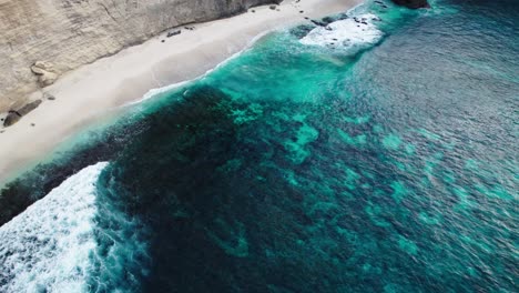 océano turquesa con olas salpicando en la playa de arena blanca en nusa penida, bali, indonesia