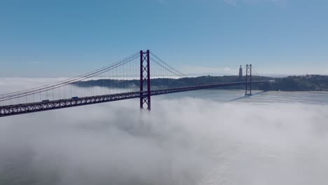 drone shot of the fog and the bridge in lisbon.