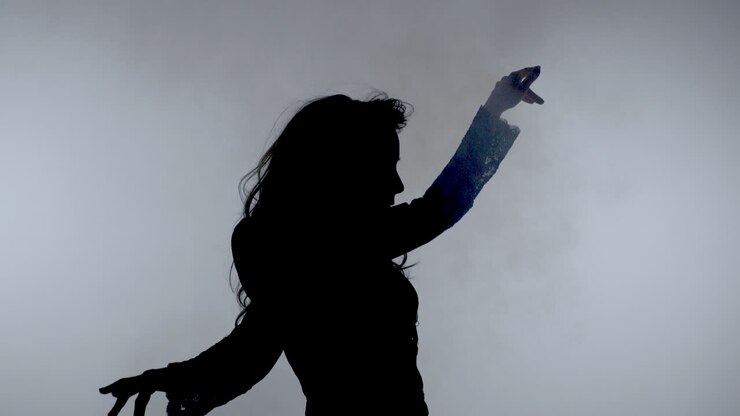 Dancing woman silhouette on smoke