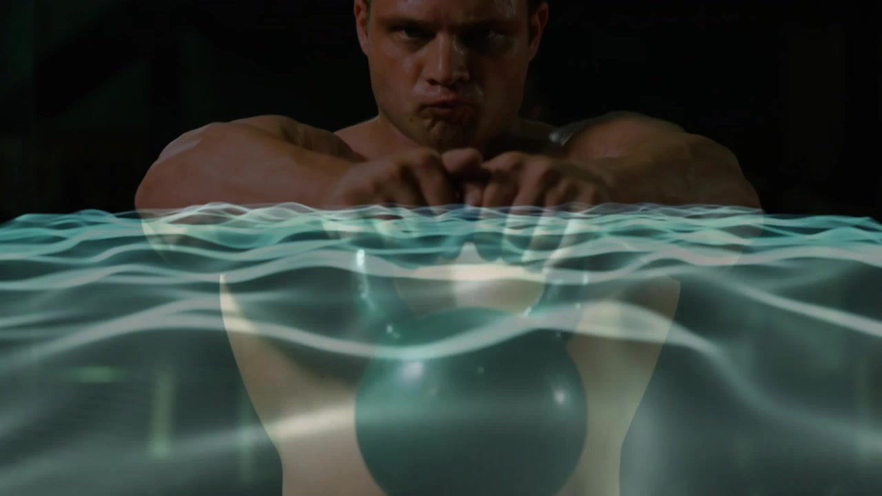 Upon gripping kettlebell, fit man pulsing in gym with wave overlay showing fitness results