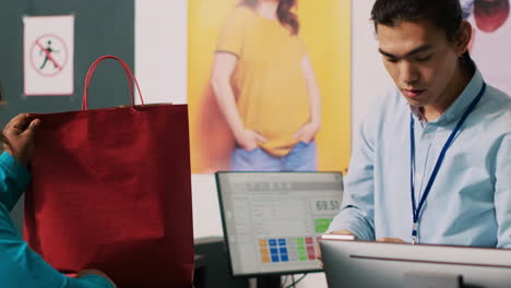 trabajador dando una bolsa a un cliente adicto a las compras