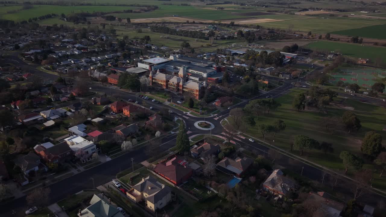 Darkening suburban streets of Bathurst with hospital nearby, golden hour fades into early evening, tilt up establish, NSW Australia