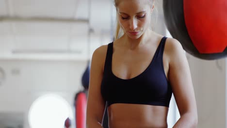 boxeadora usando teléfono móvil en el estudio de fitness 4k