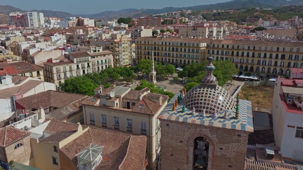 Filmato drone di Malaga, Spagna, che cattura Plaza de la Merced, architettura con tetti a motivi e viste panoramiche della città dalla collina sotto la luminosa luce mediterranea