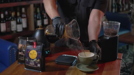 a man preparing coffee with the v60 alternative method by pouring the coffee into a cup