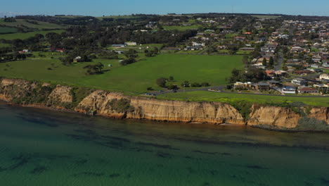 Inclinación-Aérea-Hacia-Abajo-Del-Acantilado-De-Piedra-Caliza-De-Clifton-Springs,-Australia