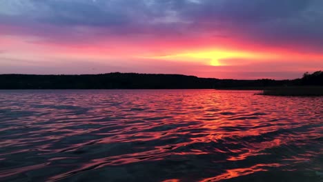 Schöne-Handgehaltene-Weitwinkelaufnahme-Des-Aspensees-In-Lerum-Schweden-Am-Späten-Abend-Mit-Einer-Waldsilhouette-Im-Hintergrund-Und-Einem-Fliegenden-Vogel