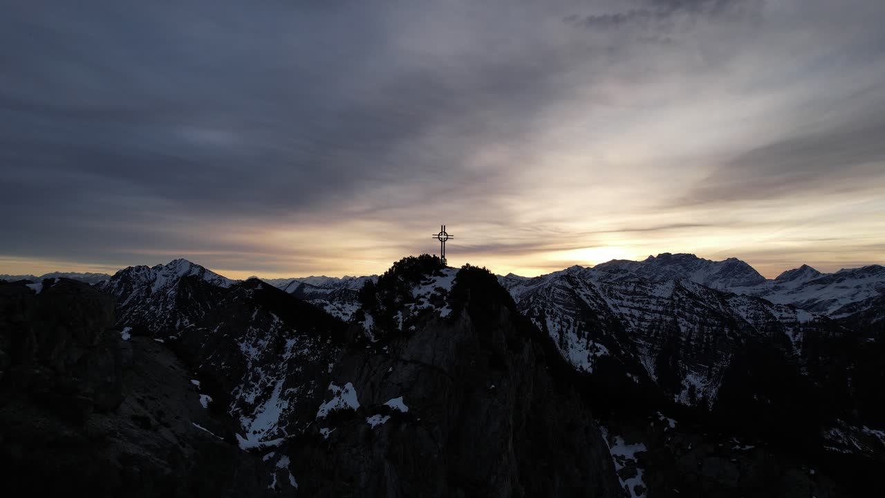 Alba in montagna con una splendida vista sulla croce in cima alla montagna