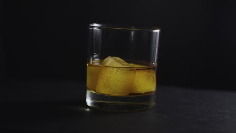 whiskey glass rotating on black background