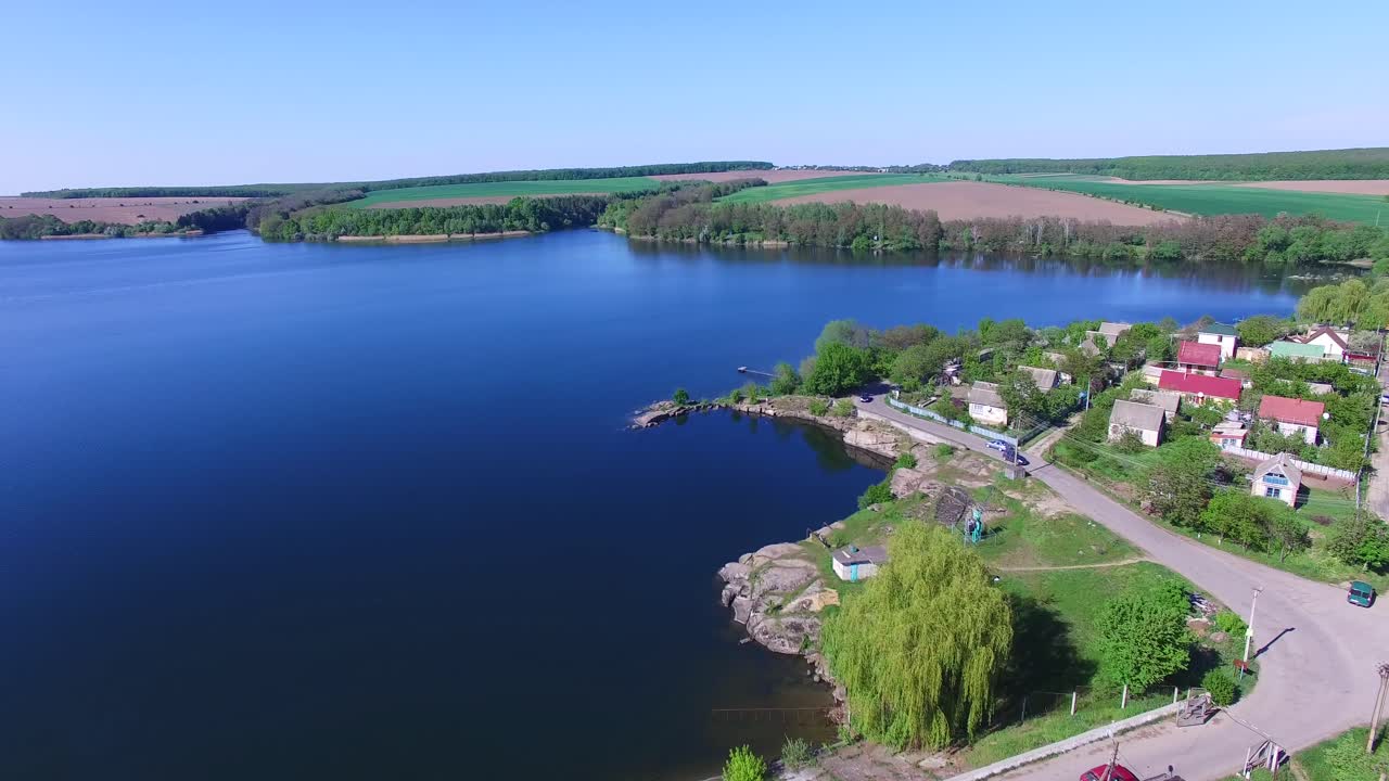 Village on the shore. Aerial view of village near pond in countryside
