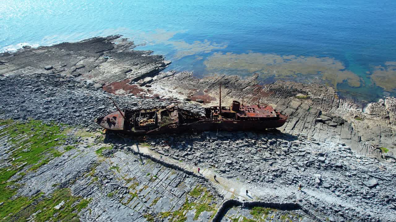 Ireland Inisheer Aran islands tourists walking to the Plessey shipwreck sights on the wild Atlantic way in summer