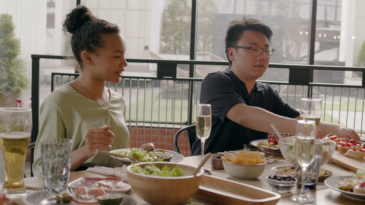 Young Boy Offers Food To An Friend At A Dinner Party