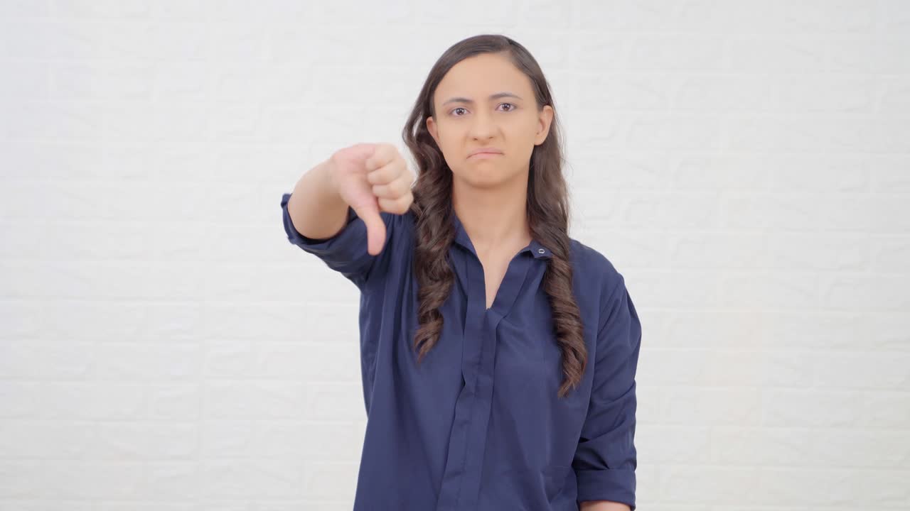 un indio decepcionado mostrando los pulgares hacia abajo