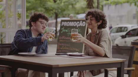 Friends Toasting with Beer at an Outdoor Cafe
