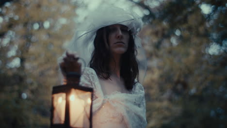 ethereal woman in white dress holding a lantern in a forest