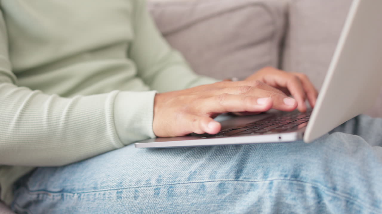 primer plano, manos de hombre y portátil en el sofá para escribir