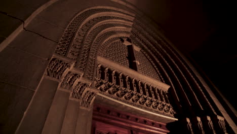 a decorated cross above the church door - camera moving up - low angle