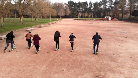 Un-Grupo-De-Amigos-Haciendo-Una-Carrera-De-Resistencia-Con-Scooters-Eléctricos