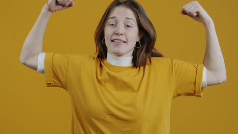 woman flexing muscles in yellow shirt