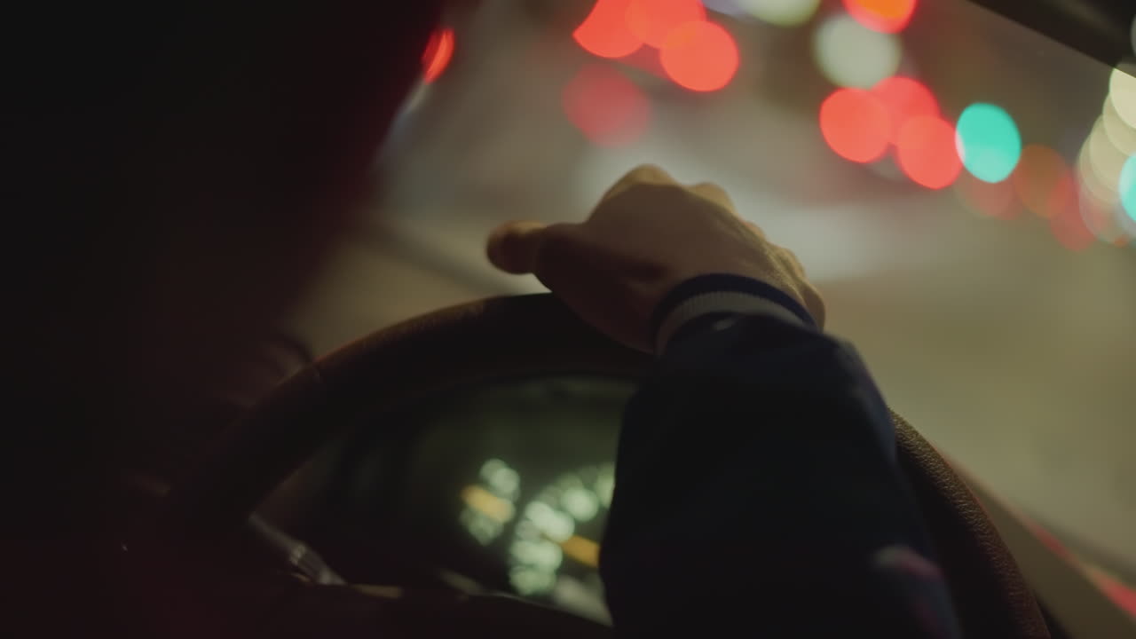 Steering wheel in neon lights, Closeup of driver handling illuminated wheel, Nighttime scene of driver gripping illuminated steering wheel with vibrant reflections and blurred city lights