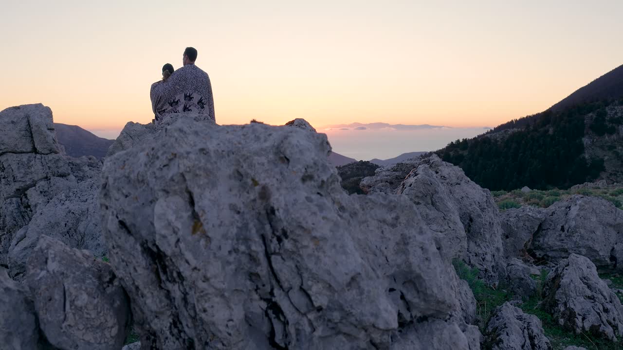 산 꼭대기 에서 해가 뜨는 것 을 지켜보는 부부
