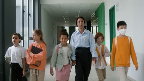 profesor y alumnos caminando por el pasillo.