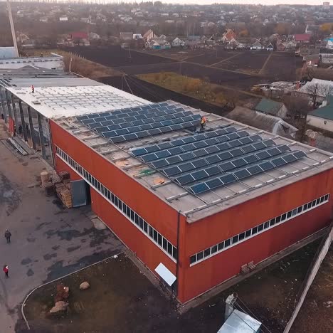 construction of solar cells on roof. photovoltaic solar panels on the roof of a building for renewable energy. solar modules on a flat roof. aerial view.