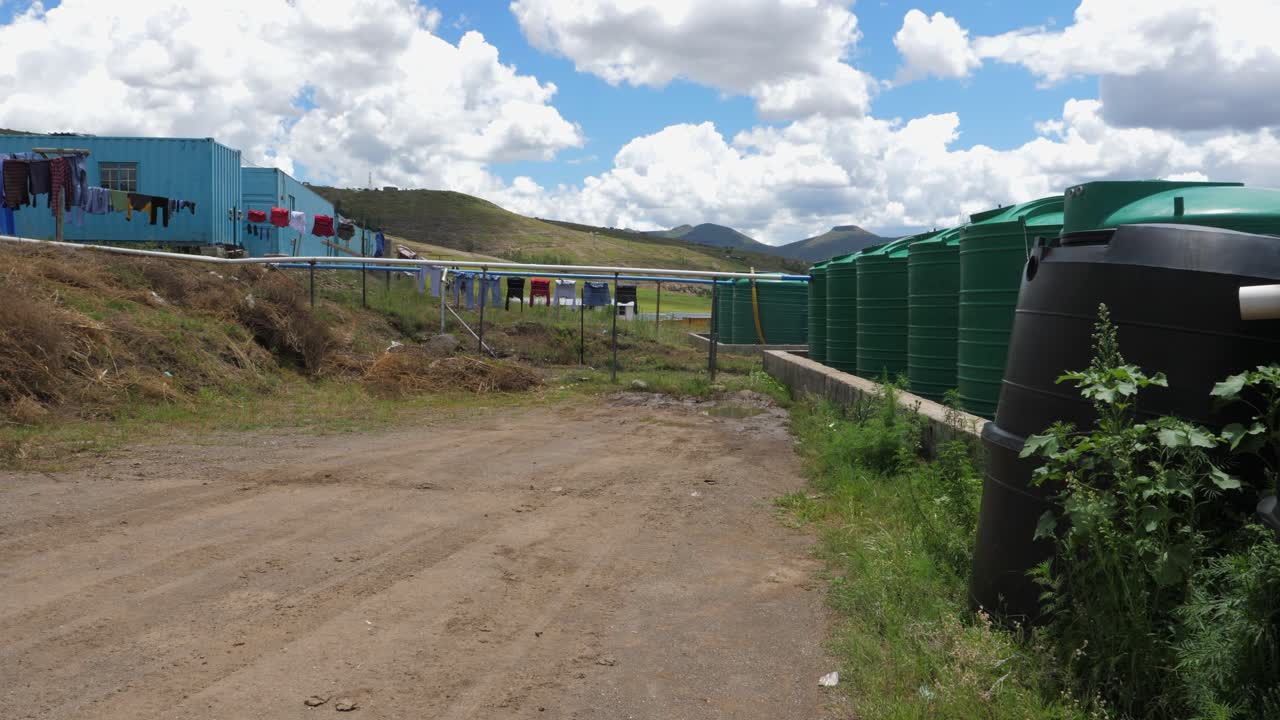 grandes cisternas recogen el agua de lluvia en el campamento de construcción de la presa de polihali