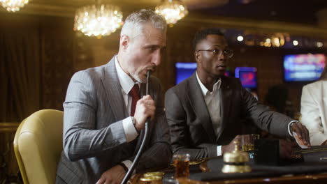 poker players smoking and drinking in the casino.