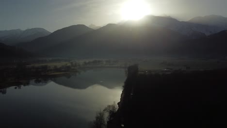 Ich-Flog-Aus-Einem-Wald-Hoch-Und-Enthüllte-Einen-See-Und-Die-Sonne,-Die-Hinter-Den-Bergen-Schien