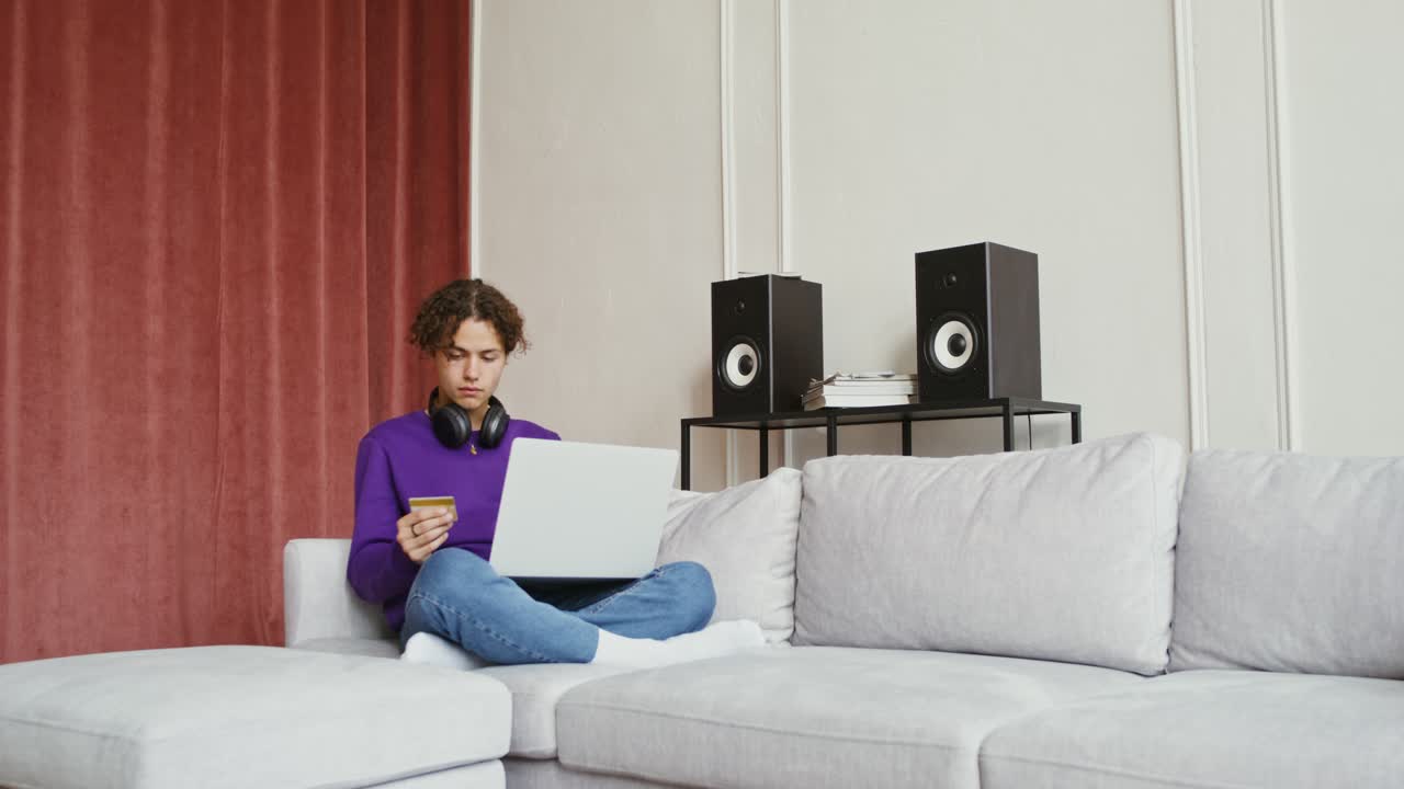 Adolescente che fa shopping online su un divano
