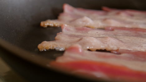 sizzling bacon in frying pan