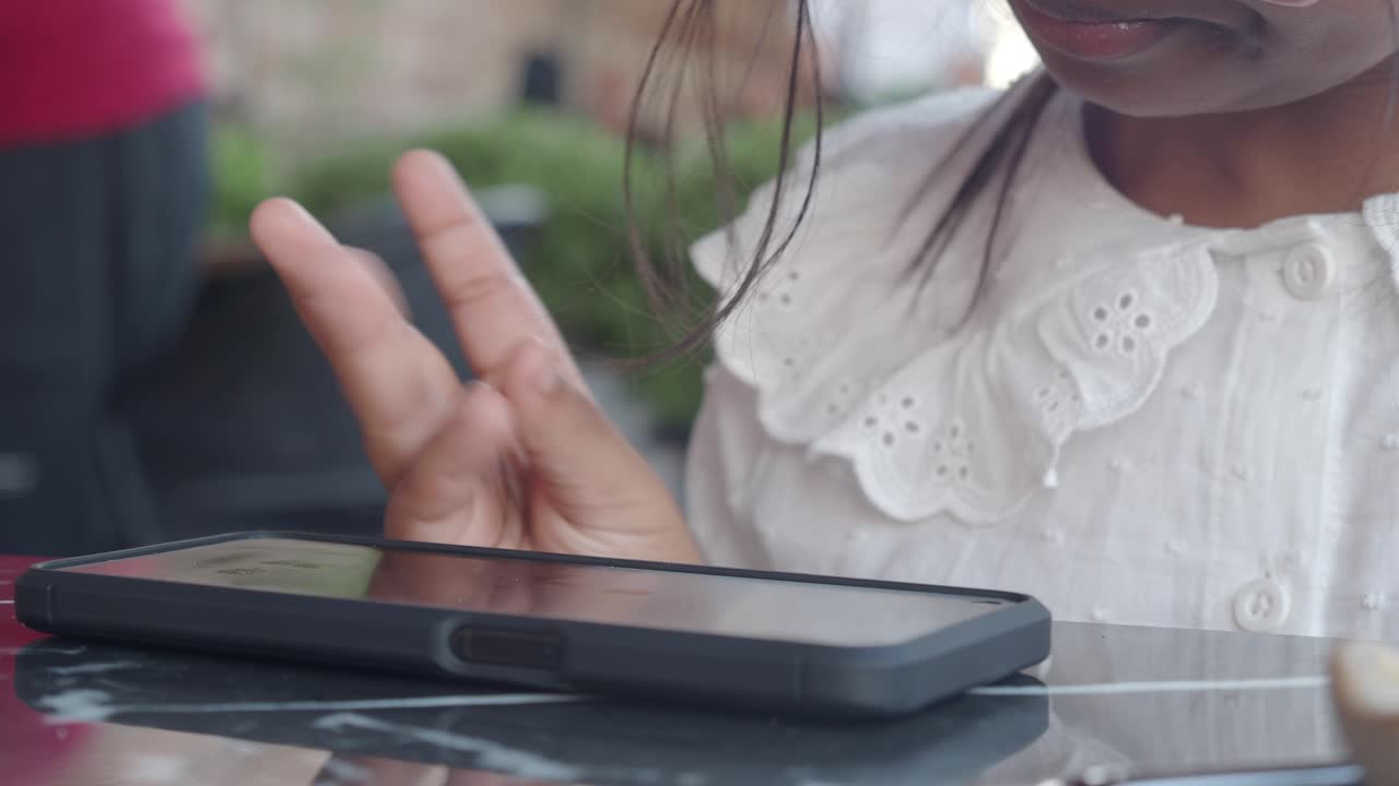 niño usando un teléfono inteligente en un café