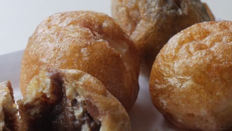 close up of tasty with chocolate stuffed profiterole, best snack or dessert for everyone, shining, one is cut to see inside