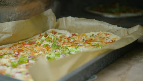 sacando una deliciosa pizza casera del horno de ladrillos, primer plano, 60 fps