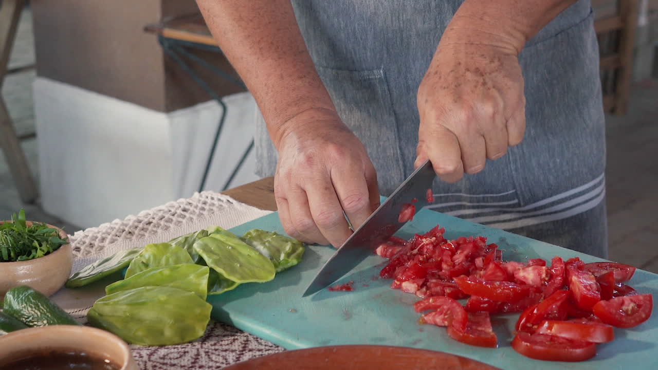 un cocinero cortando tomates con dos manos